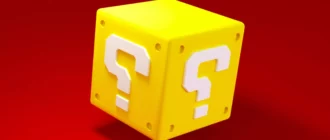 Zelta kubs ar jautājuma zīmi uz sarkana fona