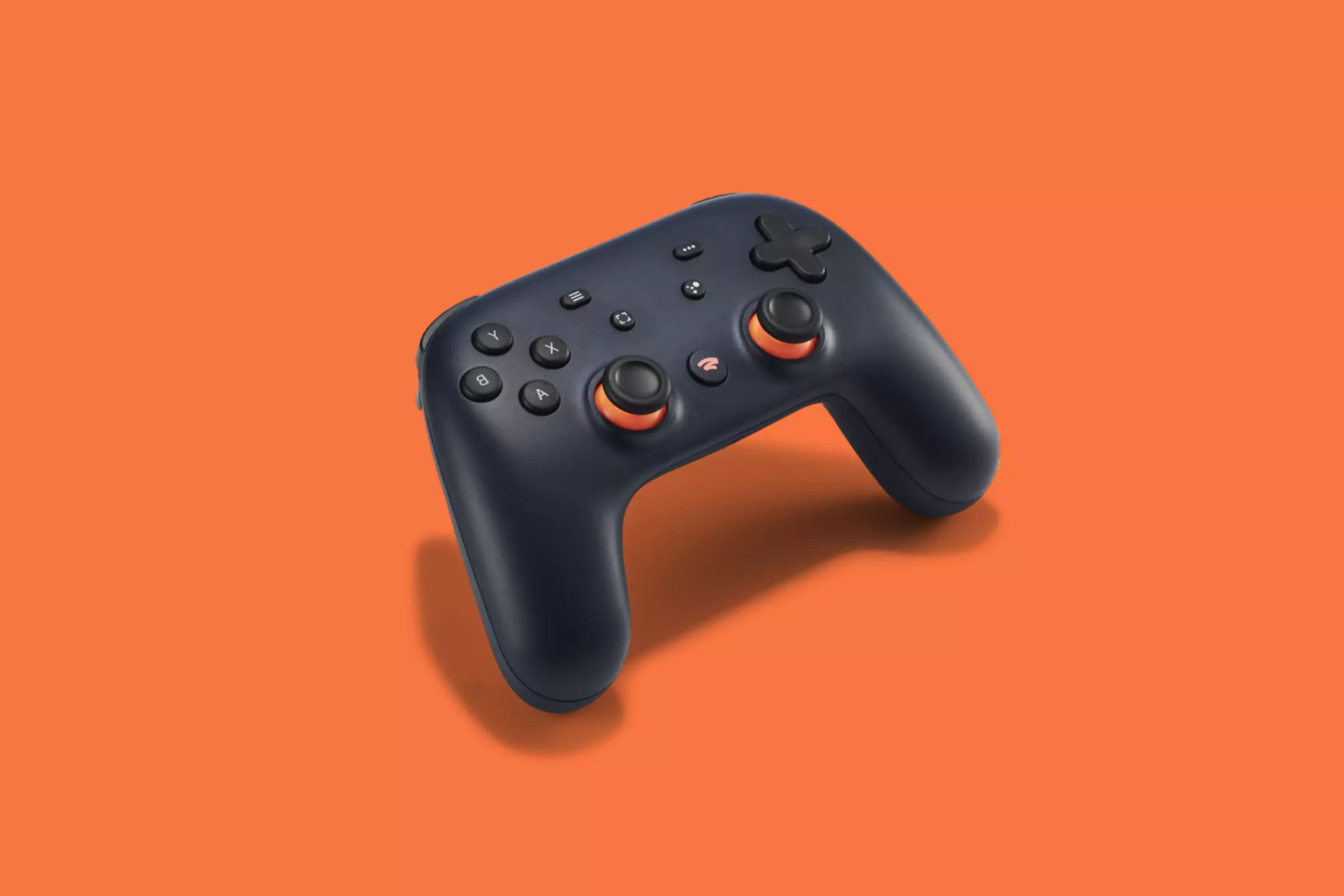 Un controler de joc video Google Stadia pe un fundal portocaliu.