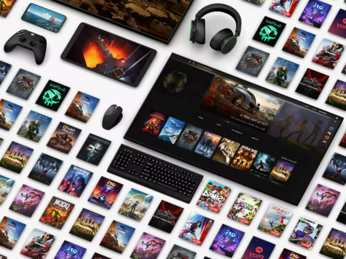 Televizor, sluchátka, klávesnice, počítačová myš a ovladač Xbox naaranžované vedle herního umění společnosti Microsoft.