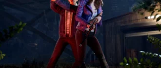 Snímek obrazovky ze hry Evil Dead The Game se dvěma postavami mířícími zbraněmi do tmy